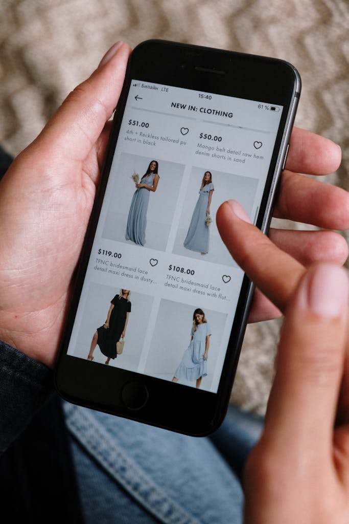 A person browsing clothing options on a smartphone for online shopping.