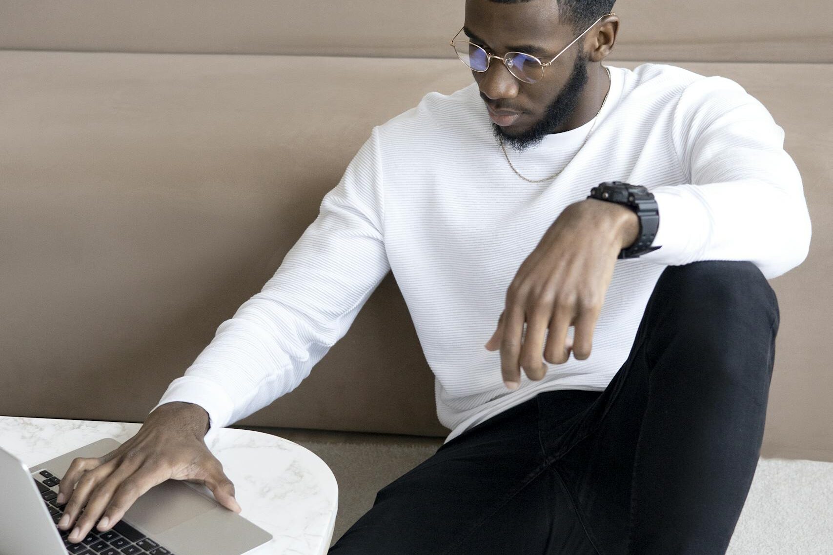 Contemporary businessman using a laptop while sitting, showcasing modern remote work lifestyle.